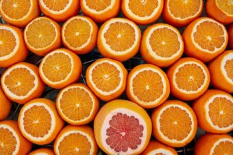 A collection of fresh, halved oranges with a single grapefruit standing out, representing personal branding for software engineers.