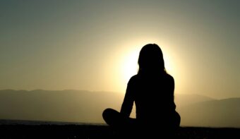 person meditating at sunrise for mindfulness and emotional intelligence