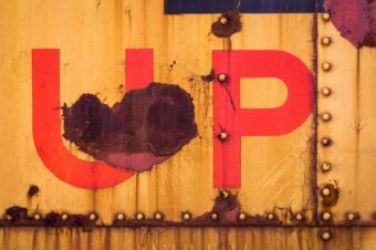 A rusted metal surface with faded red "UP" letters, symbolizing the lessons learned from a failed tech interview.